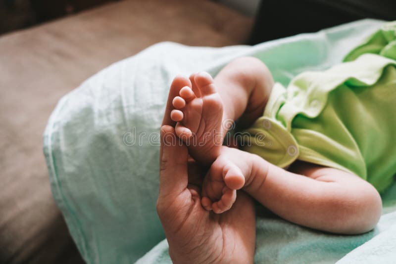 Mother`s hand touching tiny feet of newborn baby. Togetherness, new life. royalty free stock images
