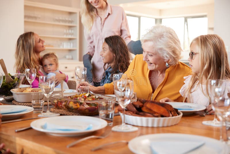 Mother Serving Food As Multi-Generation Family Meet For Meal At Home stock photography