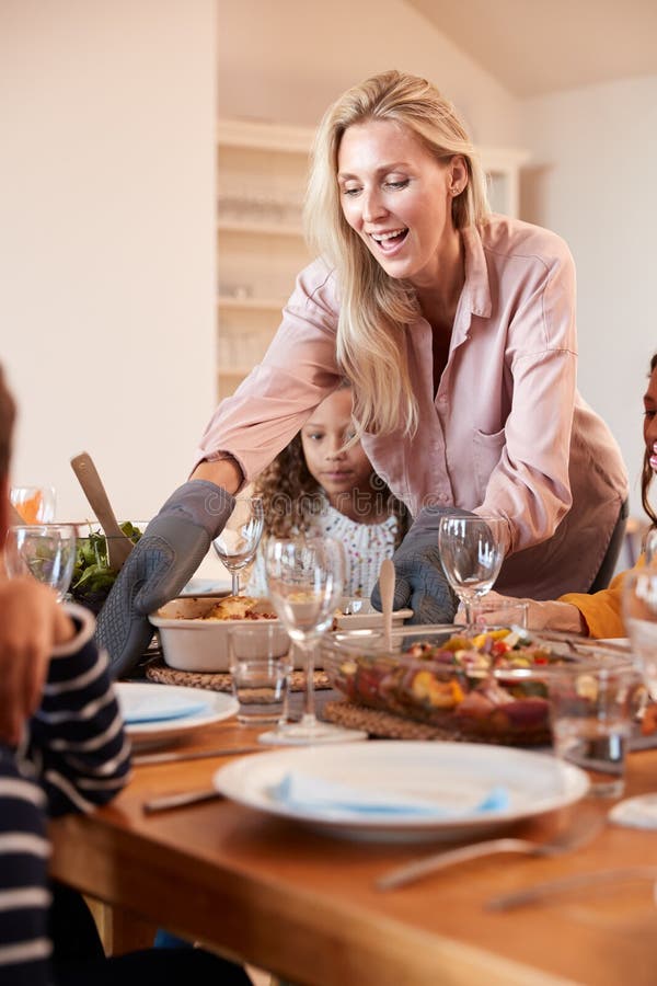 Mother Serving Food As Multi-Generation Family Meet For Meal At Home stock photos