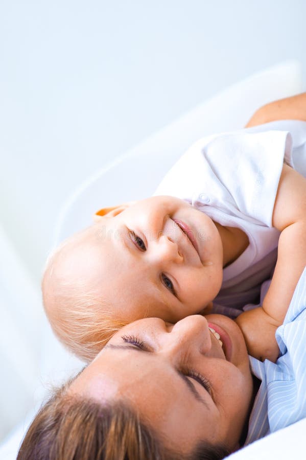 Joven madre su un nino un hijo sobre el una cama.