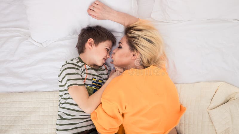 Mother with son on bed, mother and son having fun