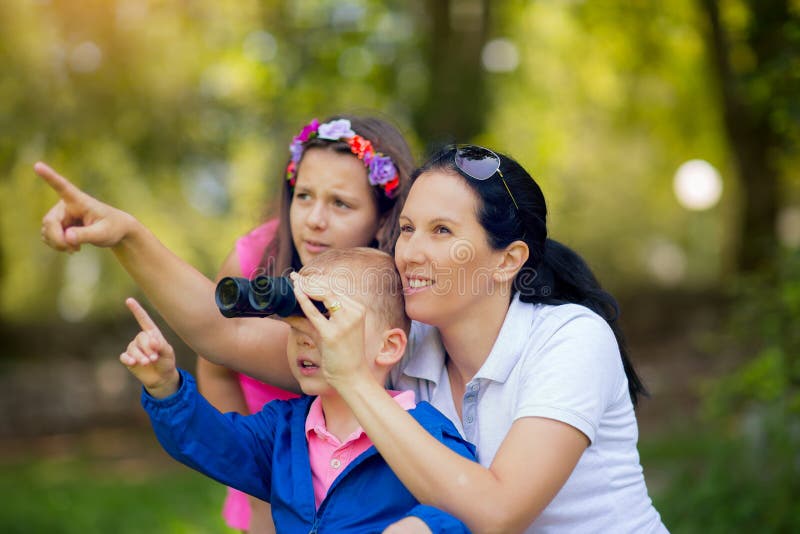 Mother and son and daughter exploring the environment with a binocular stock images