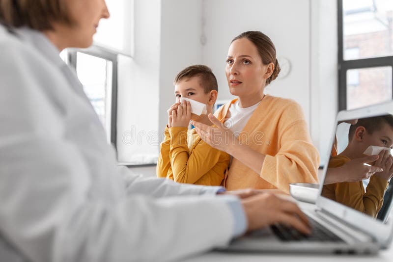 Mother, son and doctor with laptop at clinic stock image