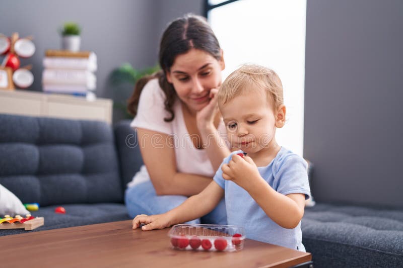 Mother and Son Eating Raspberries Sitting on Sofa at Home Stock Image