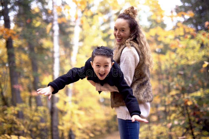 Mother with son in forest in autumn