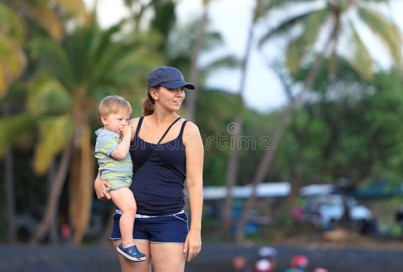 Mother and son on a Hawaiian black sand beach