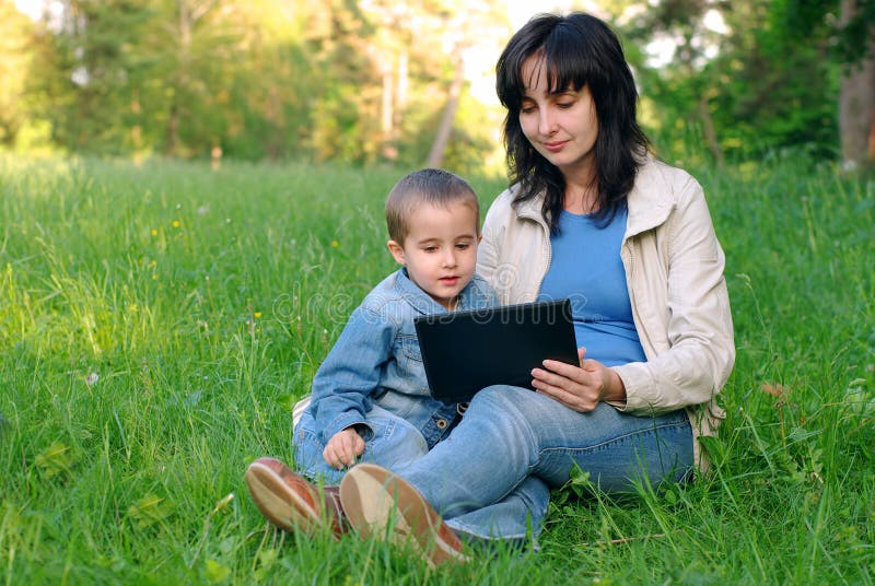 Mother and son with laptop outdoors