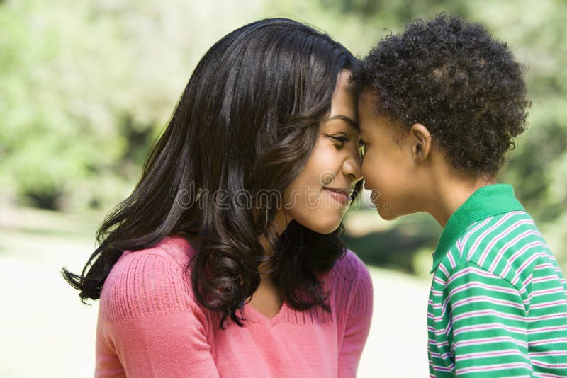 Madre e giovane figlio con teste insieme sorridenti.