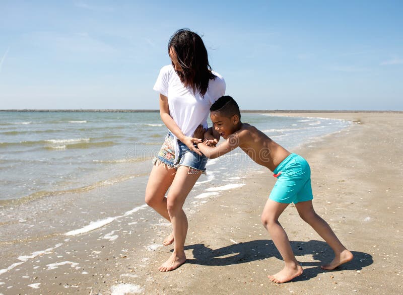 Mother and son playing at the beach. 