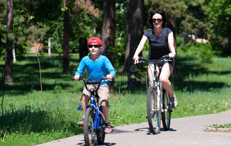 Mother and son riding bikes outdoors in summer royalty free stock photography Mother and son riding bikes outdoors in summer royalty free stock photography