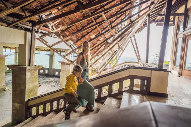 Mother and son tourists in abandoned and mysterious hotel in Bedugul. Indonesia, Bali Island. Bali Travel Concept stock photography Mother and son tourists in abandoned and mysterious hotel in Bedugul. Indonesia, Bali Island. Bali Travel Concept stock photography