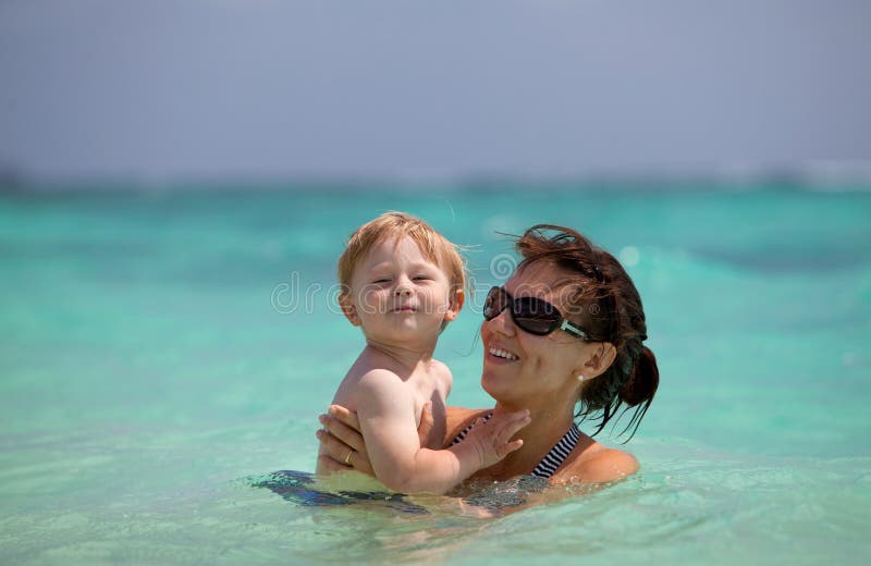 Mother and son in turquoise water