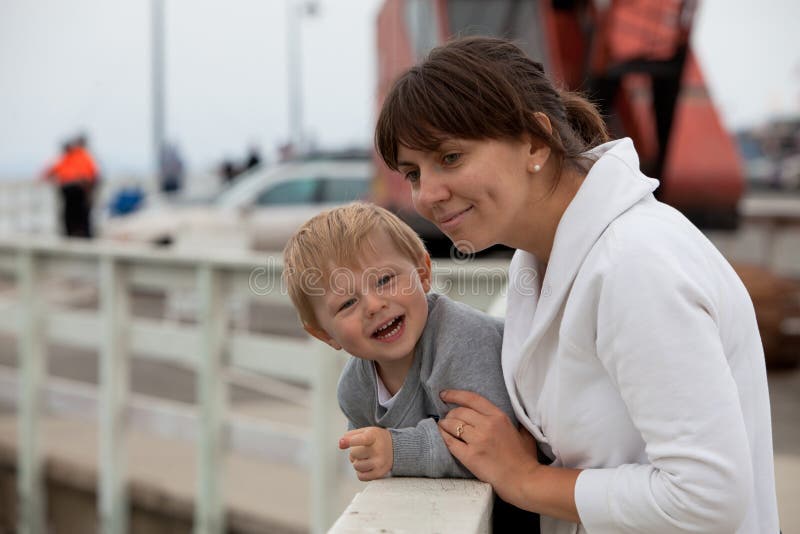 Mother and son watching wildlife from a pier