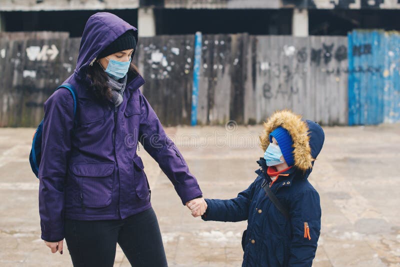 Mother and son wearing a protective mask on the street. Stop the infection. Health care concept. Mask against infectious diseases royalty free stock image Mother and son wearing a protective mask on the street. Stop the infection. Health care concept. Mask against infectious diseases royalty free stock image