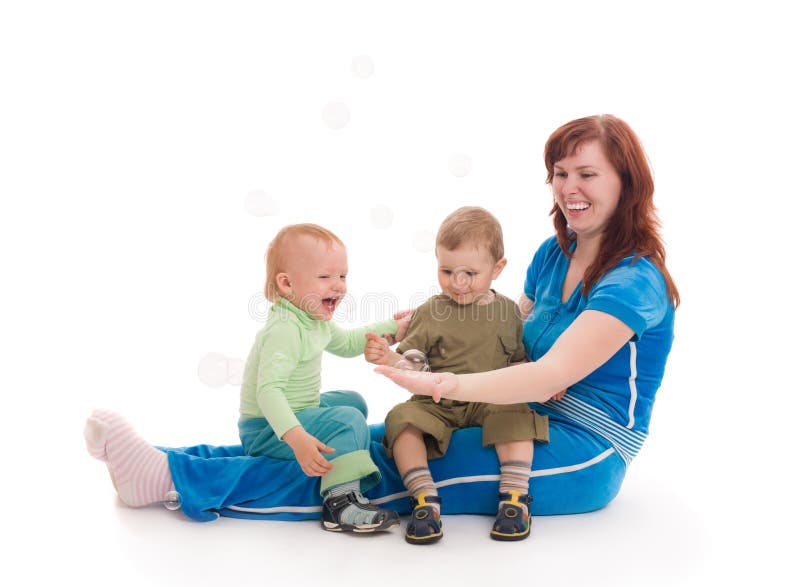 Mother with sons enjoy with coloured soap bubbles