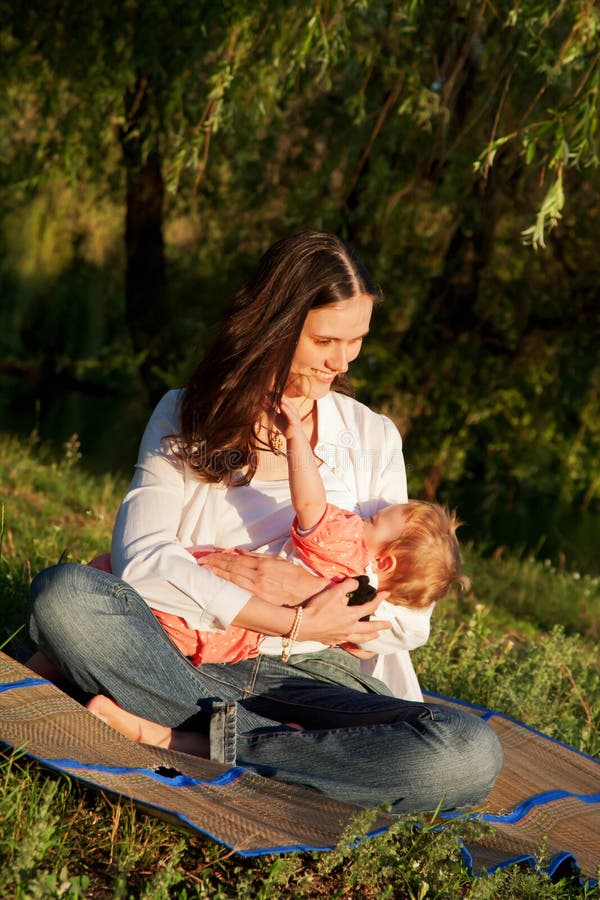 Mother taking care of baby breast feeding in the sunlight royalty free stock image Mother taking care of baby breast feeding in the sunlight royalty free stock image