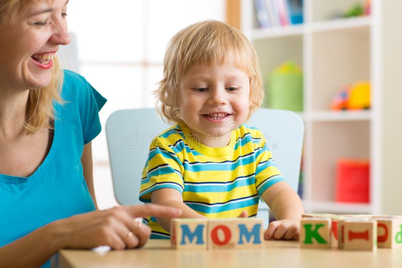 Mother teaches son child to read letters and words playing with cubes royalty free stock images Mother teaches son child to read letters and words playing with cubes royalty free stock images