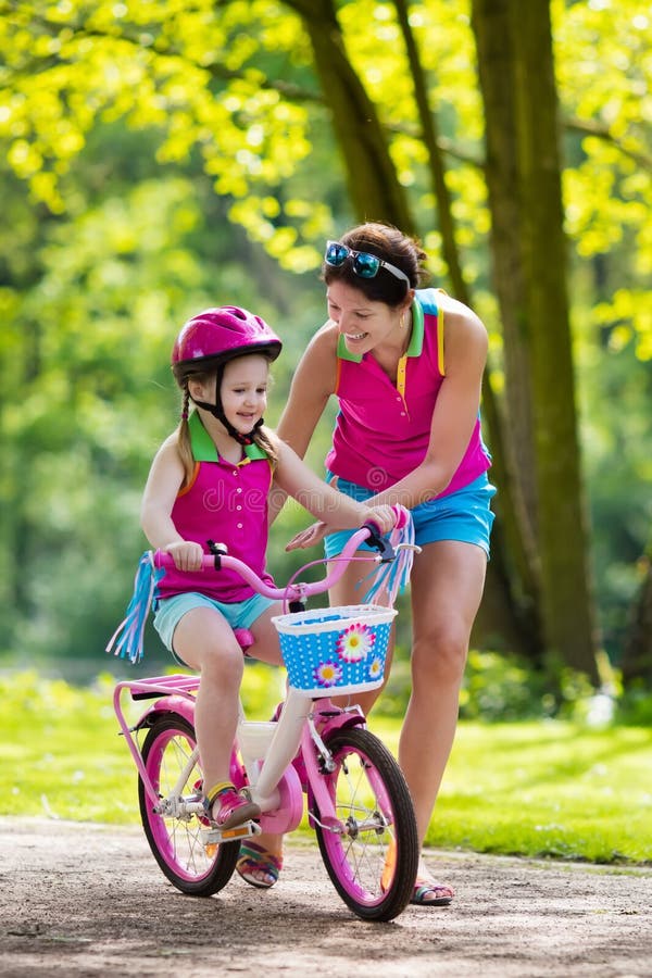 Mother Teaching Child To Ride A Bike Stock Image Image