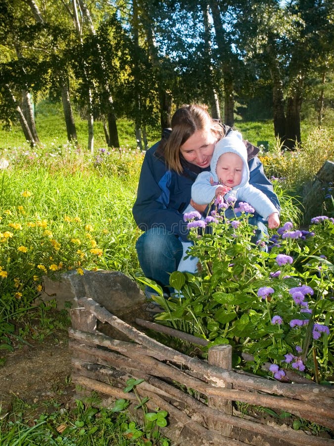 Mother teaching flowers her baby