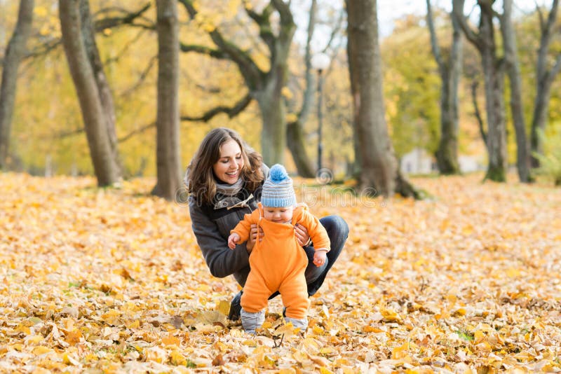 Mother teaching her toddler son to walk in the park stock photos Mother teaching her toddler son to walk in the park stock photos