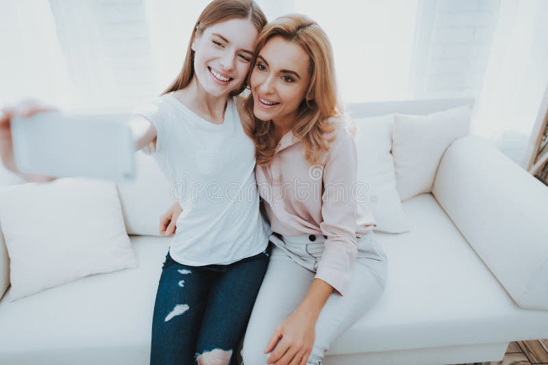 Mother and Teenage Daughter Taking Selfie on Sofa. Stock Photo - Image ...
