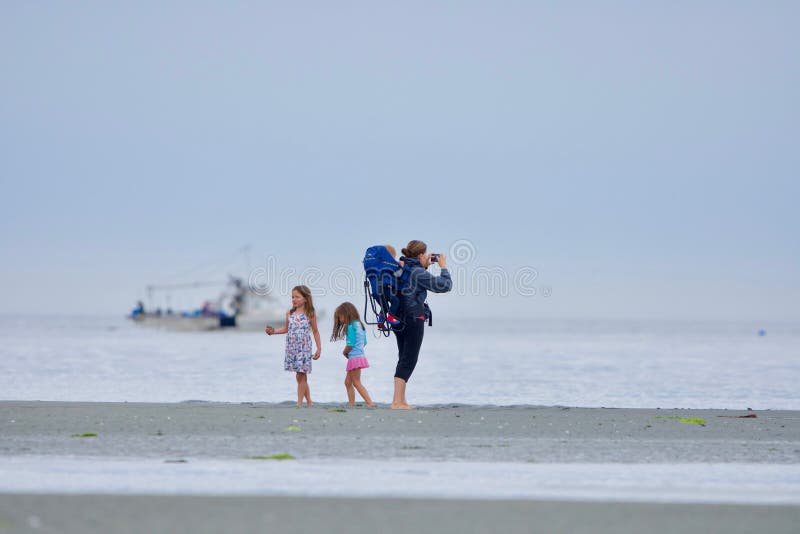 Mother with toddler and two young girls enjoy the beach at Witty`s Lagoon at low tide royalty free stock image Mother with toddler and two young girls enjoy the beach at Witty`s Lagoon at low tide royalty free stock image
