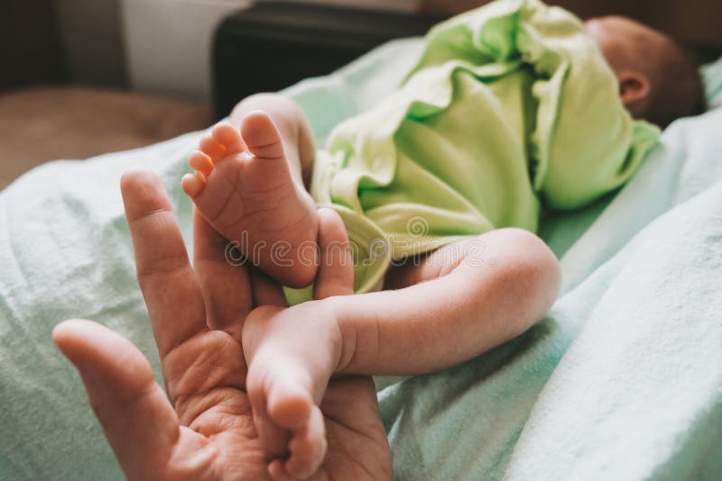 Mother touching cute little newborn baby boy feet. royalty free stock images