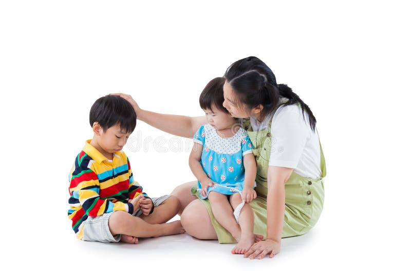 Image of mother with two little asian &#x28;thai&#x29; children &#x28;full body&#x29;, daughter sitting on lap, son feel bad, mom comforting. Great parenting image. Problems in the family. Isolated on white background. Image of mother with two little asian &#x28;thai&#x29; children &#x28;full body&#x29;, daughter sitting on lap, son feel bad, mom comforting. Great parenting image. Problems in the family. Isolated on white background