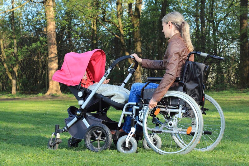 Mother in wheelchair pushing a pram with baby