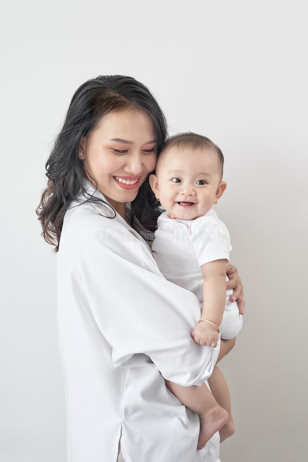 Motherhood and lifestyle concept. Smiling young mother with little baby at home royalty free stock photography Motherhood and lifestyle concept. Smiling young mother with little baby at home royalty free stock photography