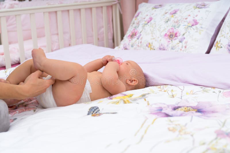 Mothers hand checking her baby diaper.