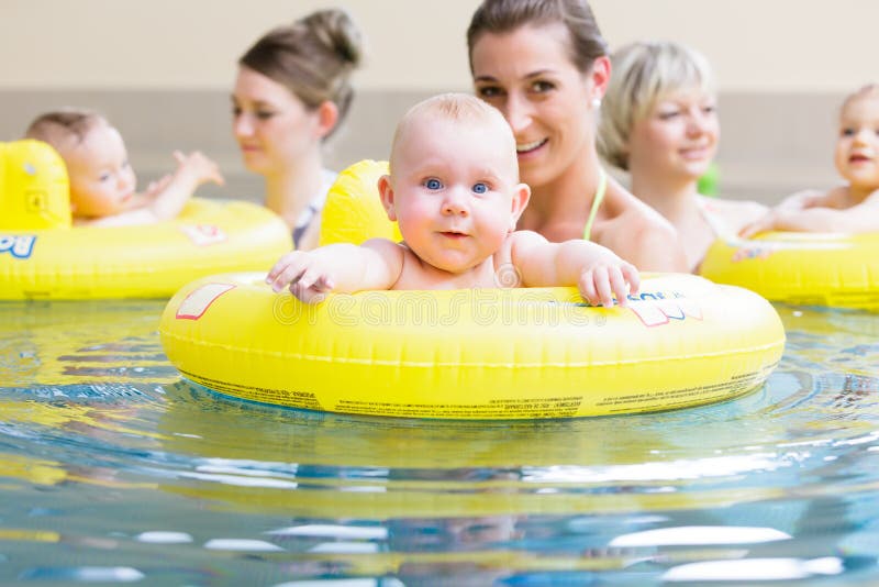 Mothers and kids having fun together playing with toys in pool