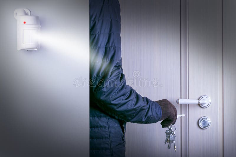 Motion sensor or detector for security system. dangerous burglar with breaking into a victim`s home door. royalty free stock images
