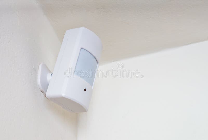 Motion sensor or detector for security system mounted on wall stock photos