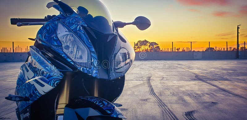 Moto bmw s1000rr em parque de estacionamento vazio ao pôr do sol