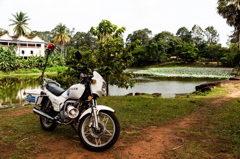 Motocicleta da polícia do turista com o lago em Angkor Wat, Camboja imagem de stock Motocicleta da polícia do turista com o lago em Angkor Wat, Camboja imagem de stock