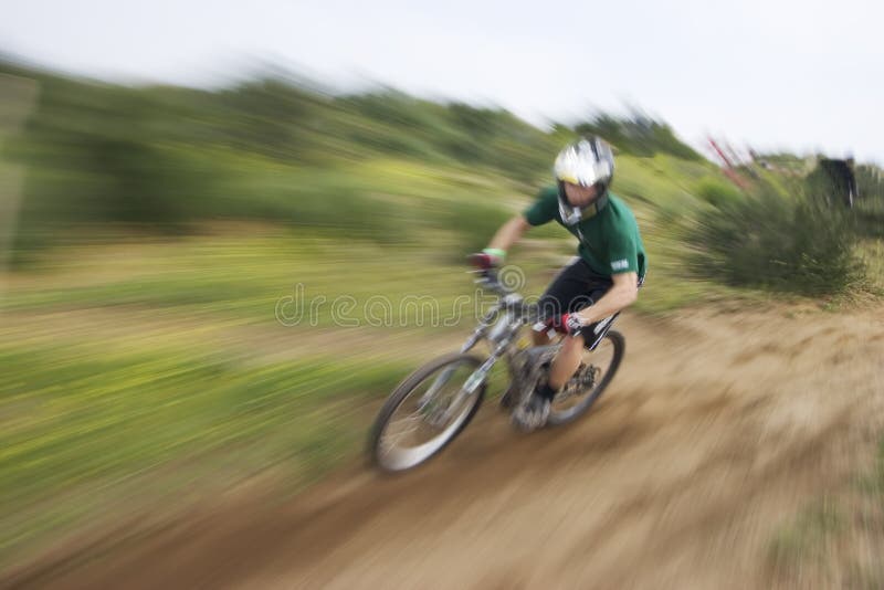 Motociclista della montagna della sfuocatura dello zoom immagine stock