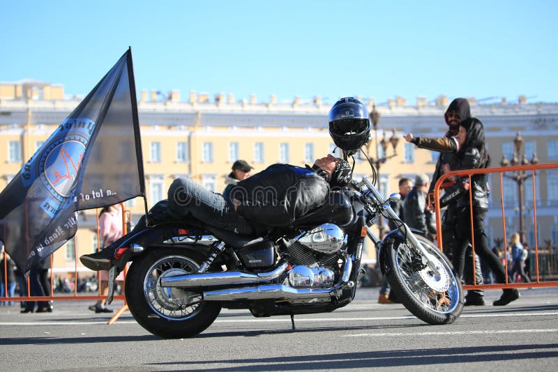 Motociclista di riposo sul quadrato del palazzo fotografia stock libera da diritti Motociclista di riposo sul quadrato del palazzo fotografia stock libera da diritti