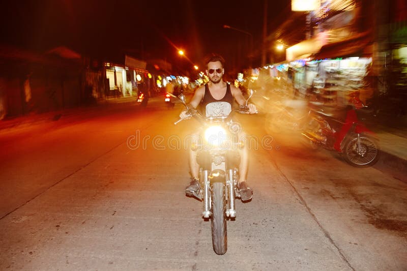 Motociclista do homem novo que monta uma motocicleta foto de stock royalty free Motociclista do homem novo que monta uma motocicleta foto de stock royalty free