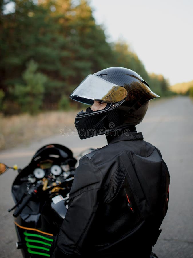 Motociclista Mira a Lado Con Medio Casco Abierto. Motociclista Con Traje De Cuero Solo Motocicleta Imagen de archivo - Imagen de negro: 208782271