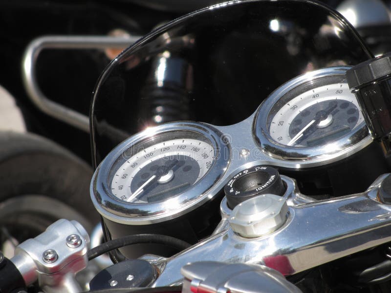 Motorcycle dash display instruments with speedometer and tachometer.
