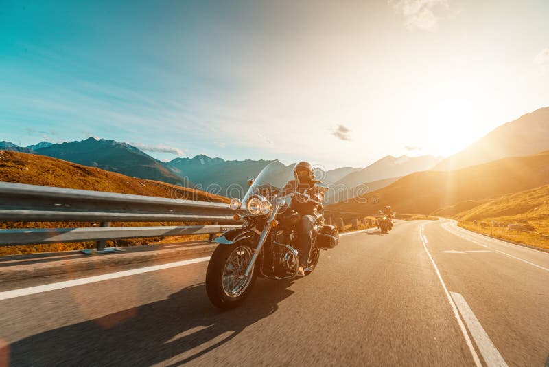 Motorcycle driver riding japanese high power cruiser in Alpine highway on famous Hochalpenstrasse, Austria. stock photography Motorcycle driver riding japanese high power cruiser in Alpine highway on famous Hochalpenstrasse, Austria. stock photography
