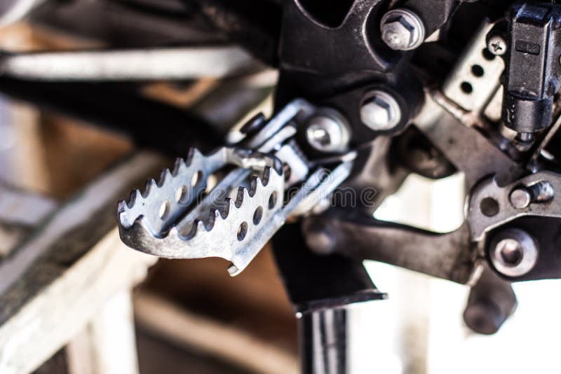 Motorcycle Foot Gear Position at Frame on Cement Flooring Closeup