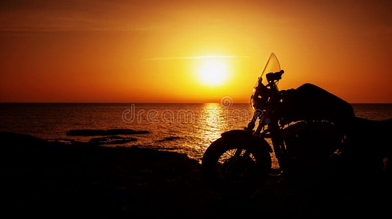 Picture of luxury motorcycle on the beach in night, silhouette of motorbike on sunset, Harley Davidson, active life, summer sports, freedom lifestyle, speed transport, leisure and fun concept. Picture of luxury motorcycle on the beach in night, silhouette of motorbike on sunset, Harley Davidson, active life, summer sports, freedom lifestyle, speed transport, leisure and fun concept