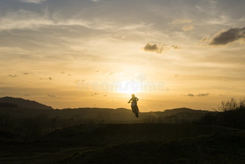 Motorcyclist riding off road during sunset. Slovakia