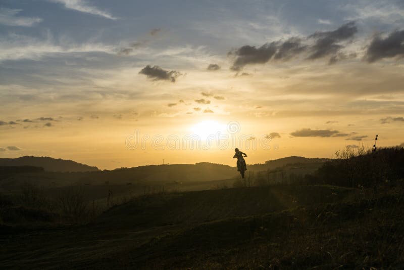 Motocyklista jazdiaci mimo cesty pri západe slnka. Slovensko