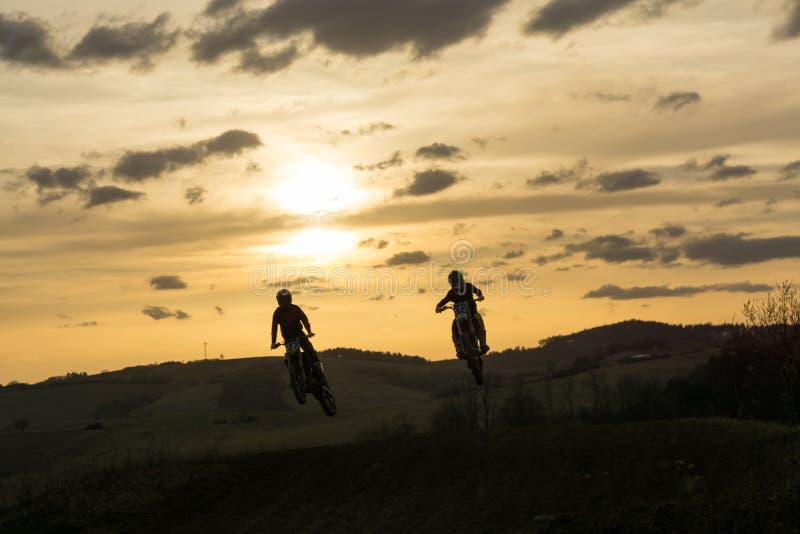 Motocyklista jazdiaci mimo cesty pri západe slnka. Slovensko