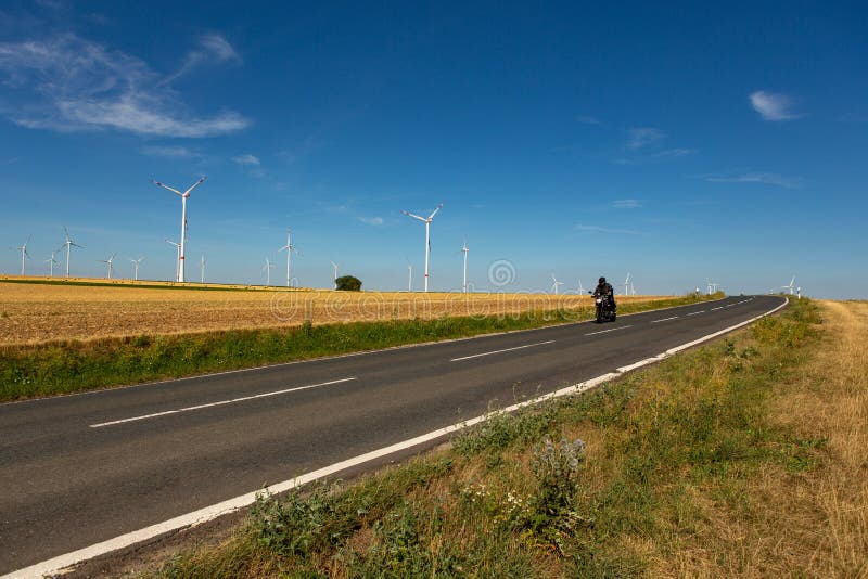 A motorcyclist and wind turbines on the background