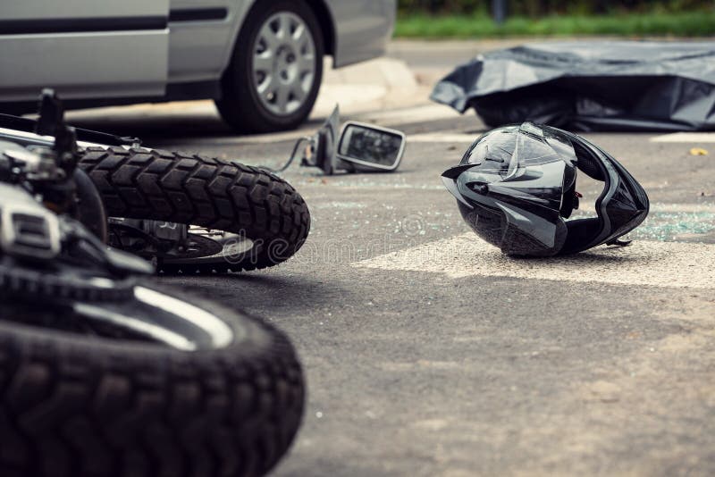 Motorcykel och hjälm på gatan efter farlig trafikinci royaltyfri fotografi Motorcykel och hjälm på gatan efter farlig trafikinci royaltyfri fotografi