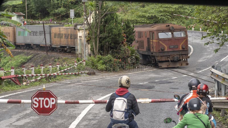 Motorfietsen met passagiers die op de trein wachten om over te gaan, Hai Van Pass, Vietnam royalty-vrije stock afbeeldingen Motorfietsen met passagiers die op de trein wachten om over te gaan, Hai Van Pass, Vietnam royalty-vrije stock afbeeldingen